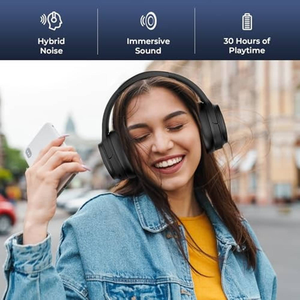 Black over-ear wireless headphones worn by a smiling woman