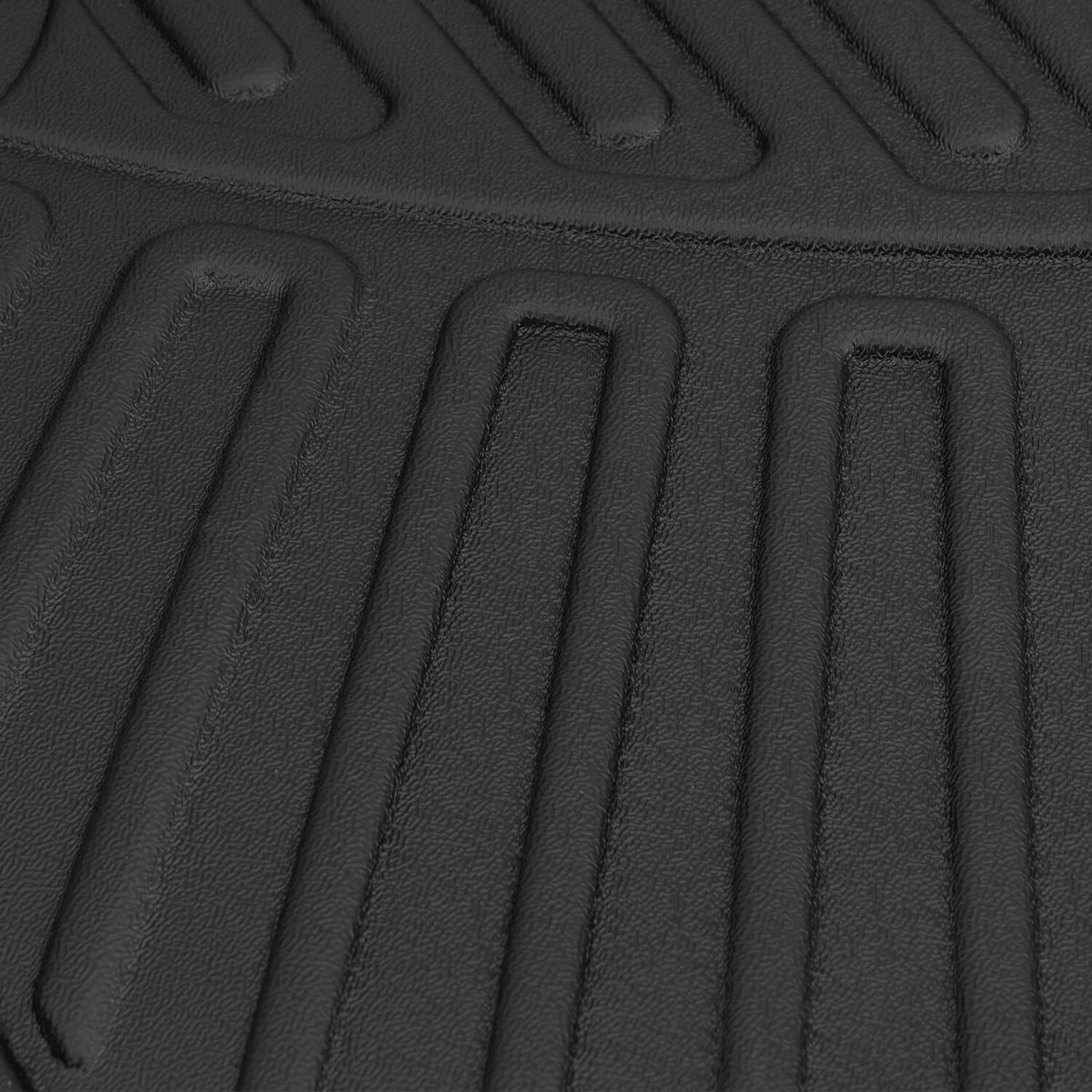 Black TPE floor mat texture close-up with raised ribbed grooves