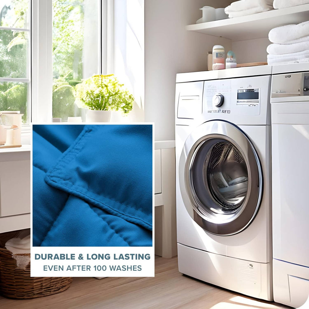 Blue comforter fabric close-up with stitching, beside laundry washing machine