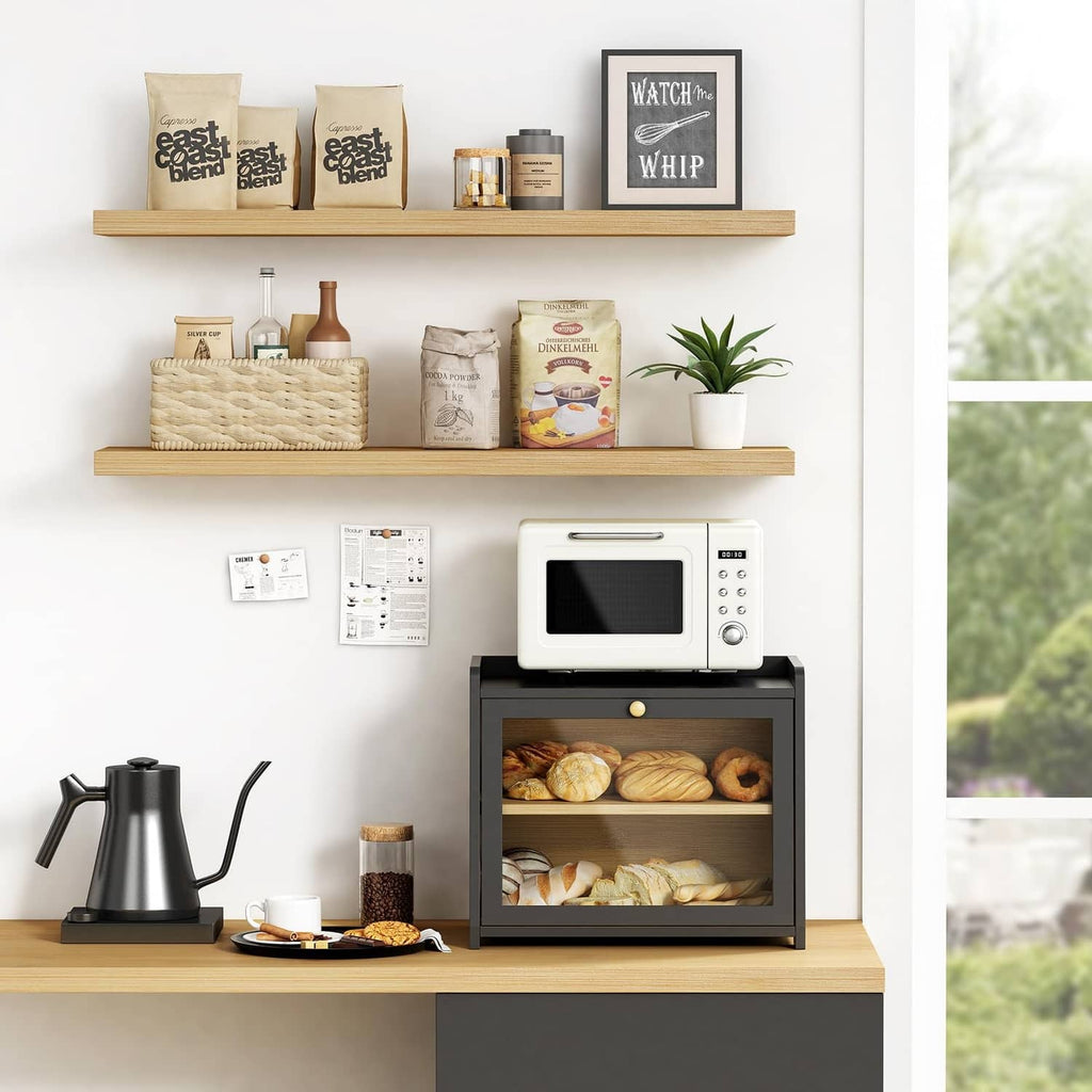 Black two-tier bread box on countertop with open front and breads on upper and lower shelves