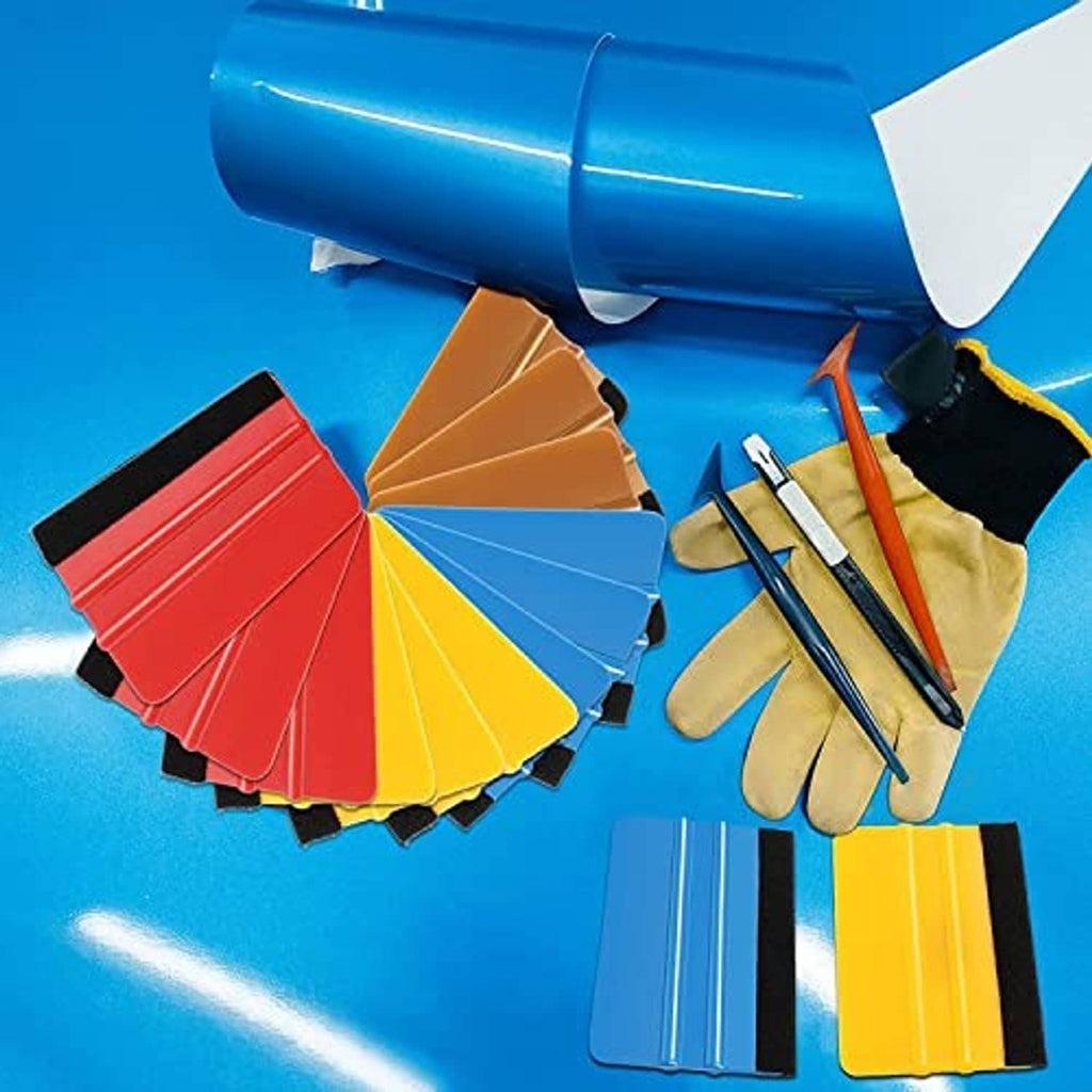 Assorted color felt-edge squeegee tools beside gloves and cutting tools for vinyl