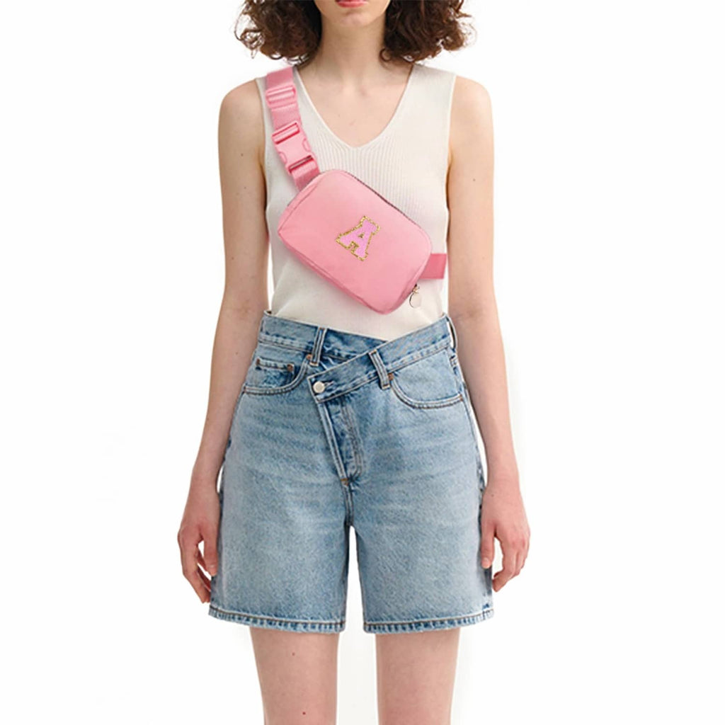 Peach crossbody pouch bag with letter A patch worn over shoulder