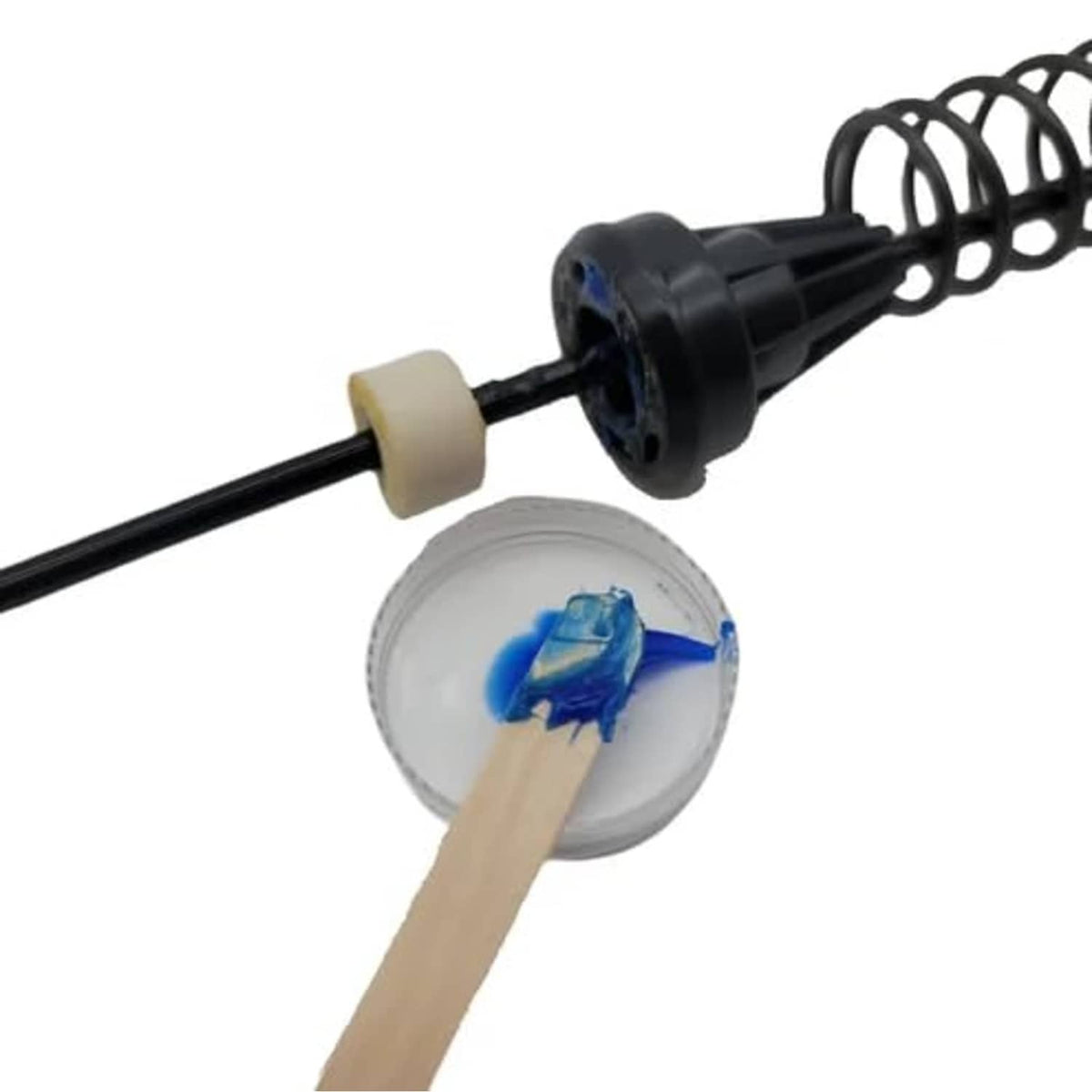 Grease applicator tool with black rod, spring, and small white nozzle pieces