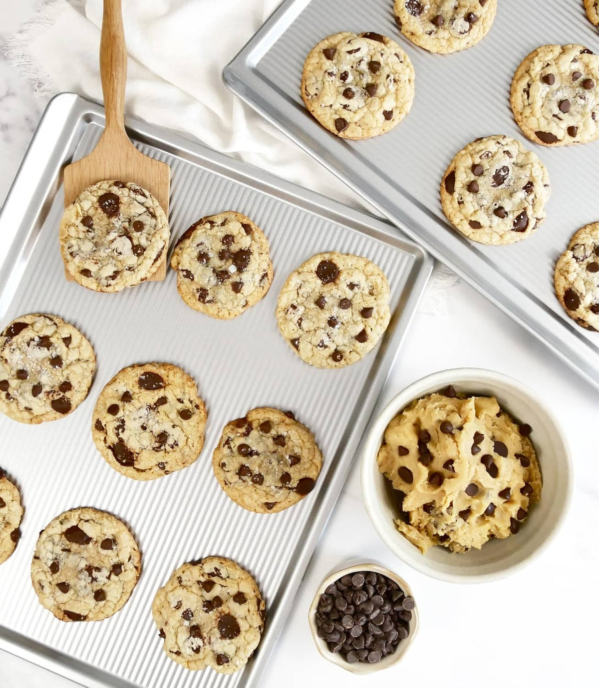 Nonstick cookie sheet with baked chocolate chip cookies in rows
