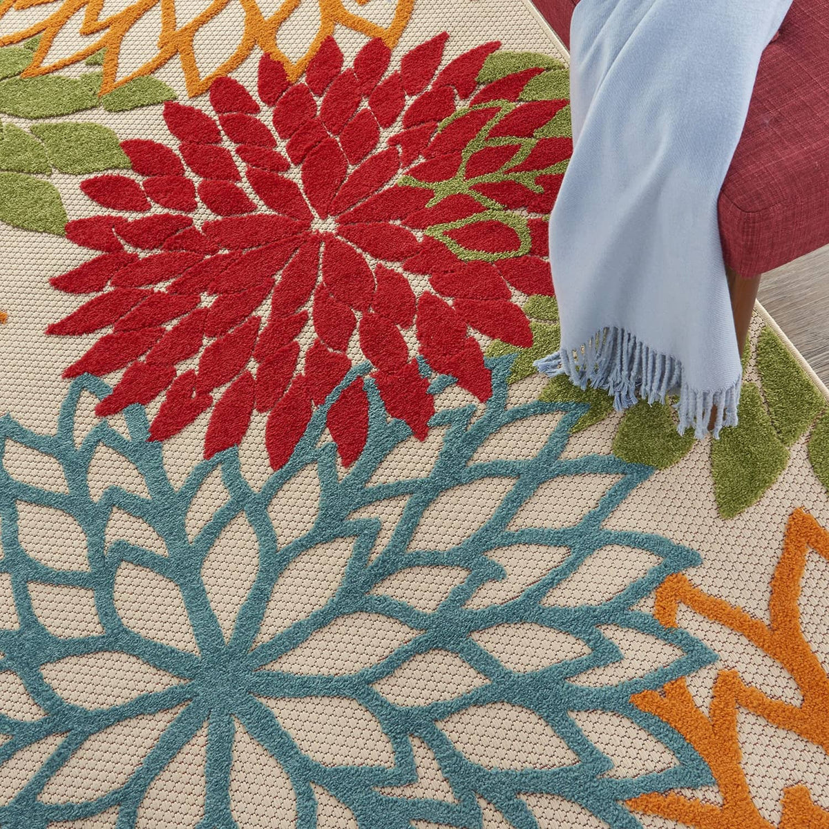 Tropical area rug close-up of red and teal flower pattern with green accents