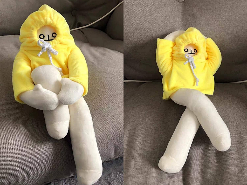 Yellow hooded banana man plush lying on gray couch, white legs and face