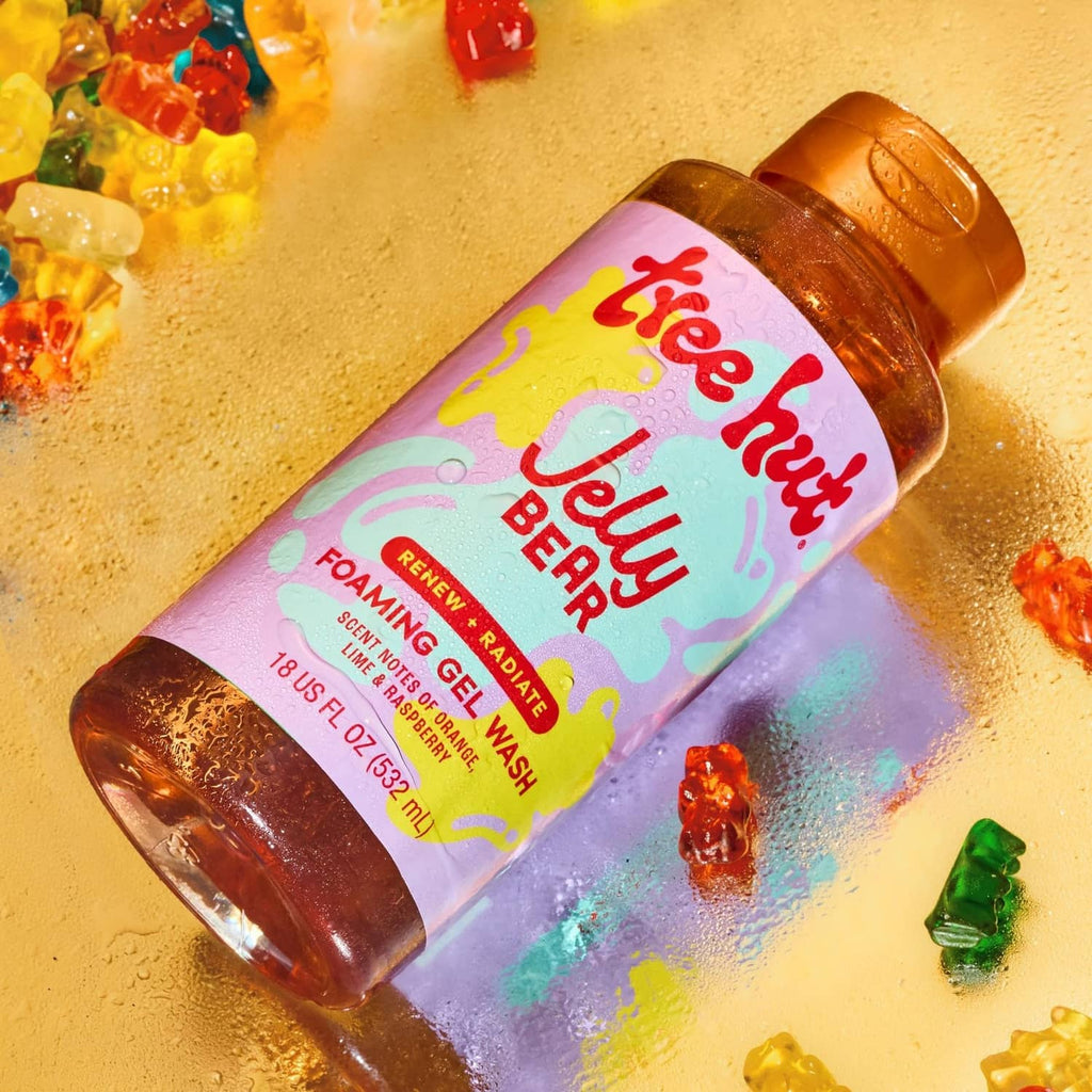 Orange foaming gel body wash bottle angled with colorful splash around it