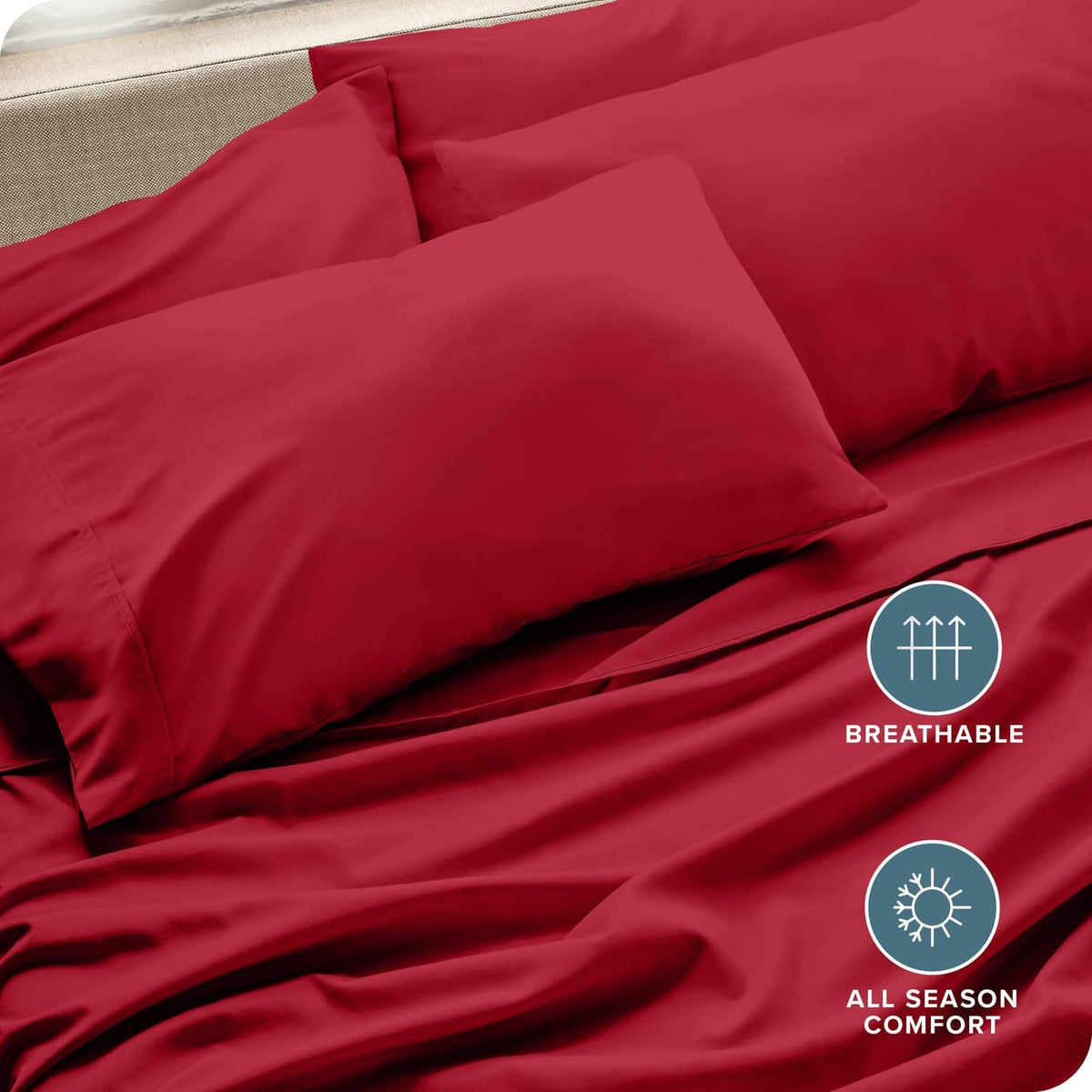 Red microfiber pillowcases with visible seams on top of folded bedding