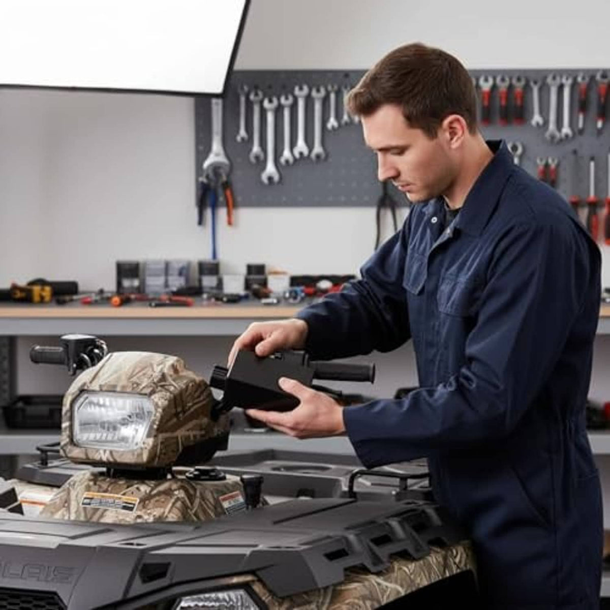 CDI ignition control box being installed on an ATV dash area by a mechanic