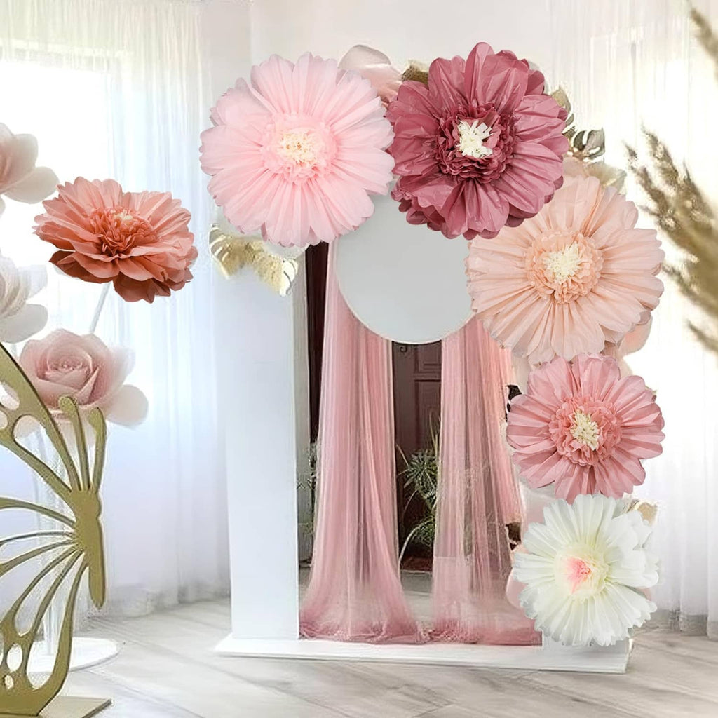 Hanging tissue paper flower decorations in pink, white, and blush tones