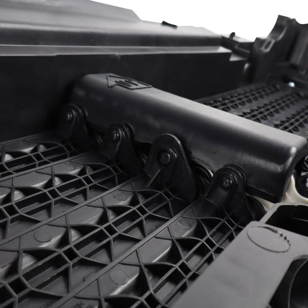 Close-up: black actuator cover and mounting points on upper radiator grille air shutter