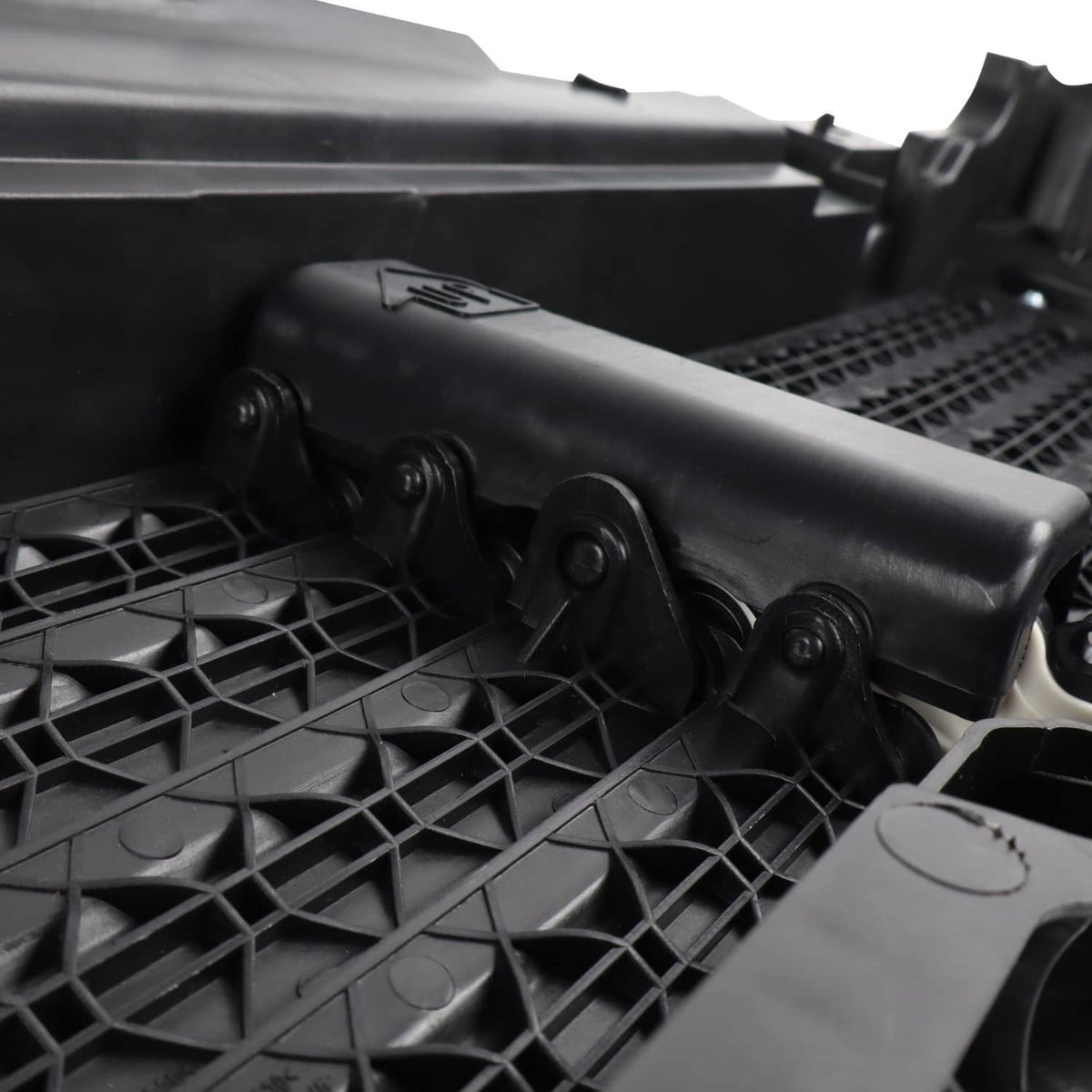 Close-up: black actuator cover and mounting points on upper radiator grille air shutter