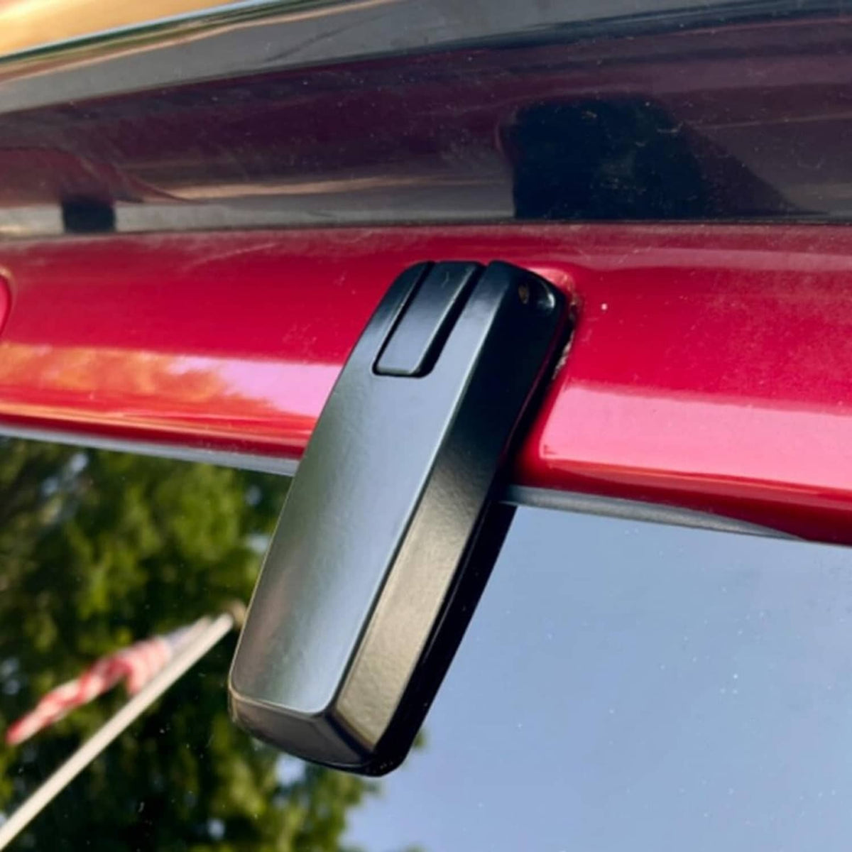 Black liftgate window hinge mounted on vehicle, close-up of side bracket
