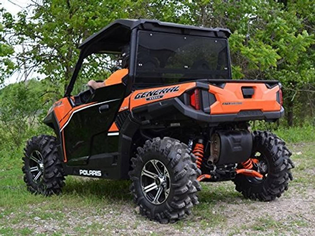 Dark-tinted rear windshield on an orange-and-black UTV cab with black roof