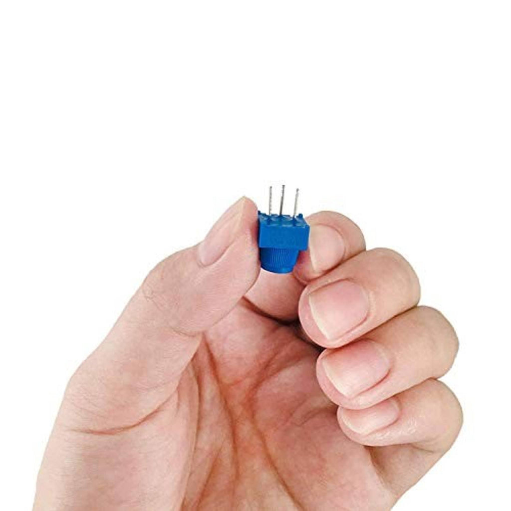Hand holding a blue trimmer potentiometer with adjustment knob and 3 metal pins