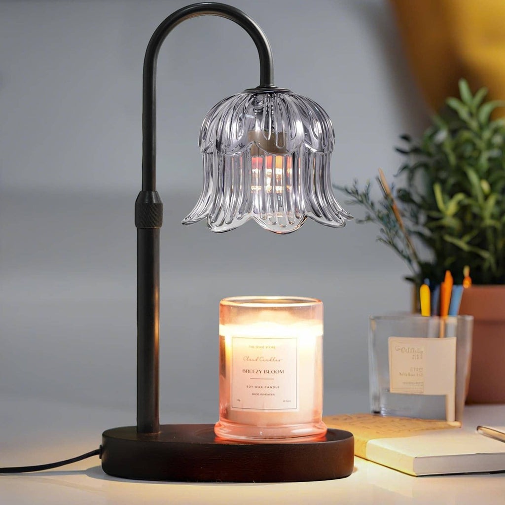Black candle warmer lamp with ribbed glass shade and glowing candle on round base