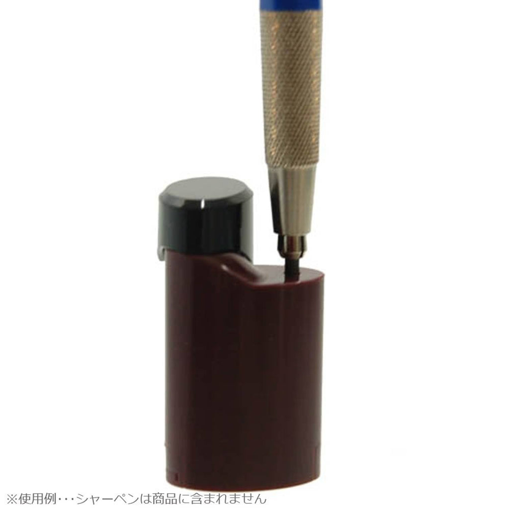 Pocket pencil sharpener with pencil inserted into maroon body and black top