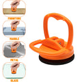 Orange suction cup dent puller tool with loop handle and black rubber base