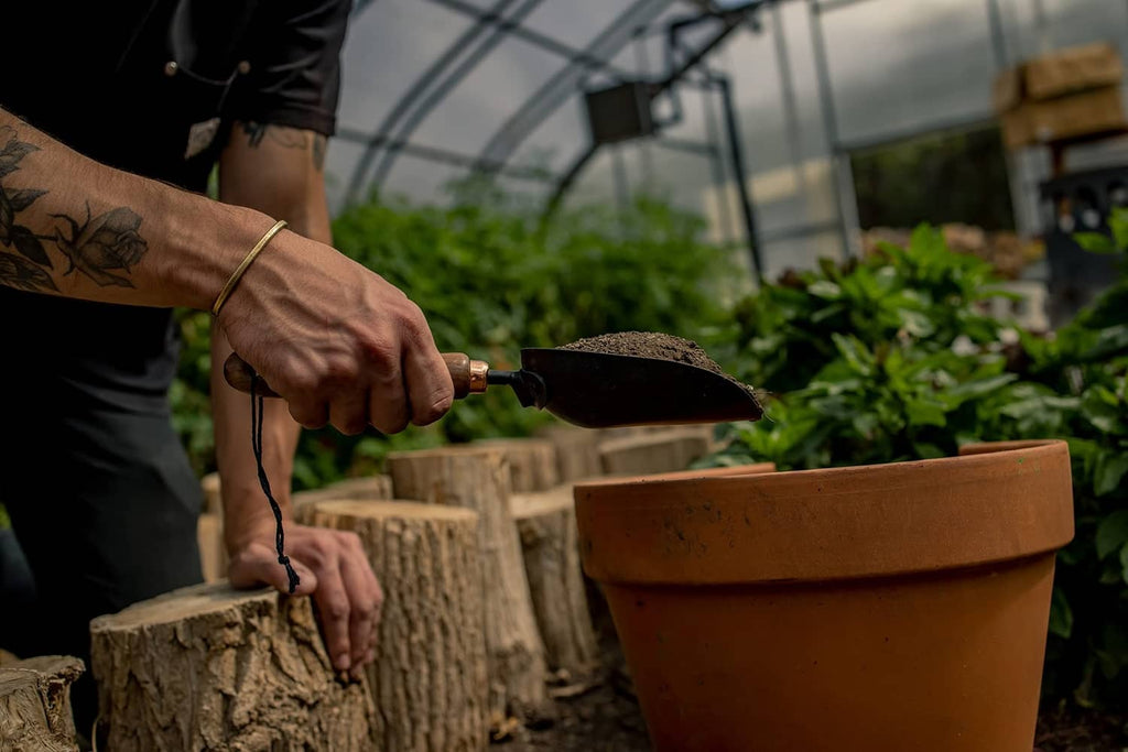 Garden scoop shovel held in hands while digging in outdoor soil