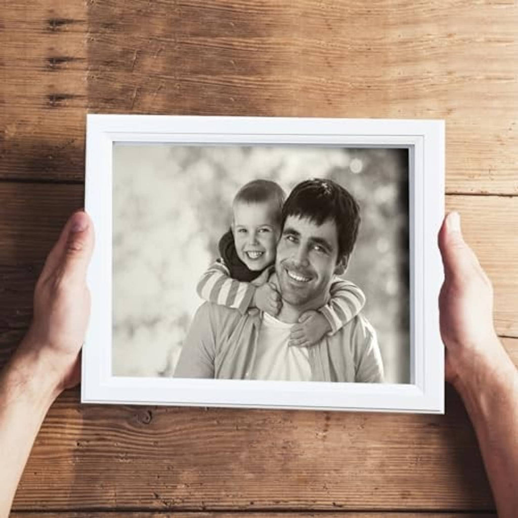 White wooden 8x10 picture frame held by hands with black-and-white portrait