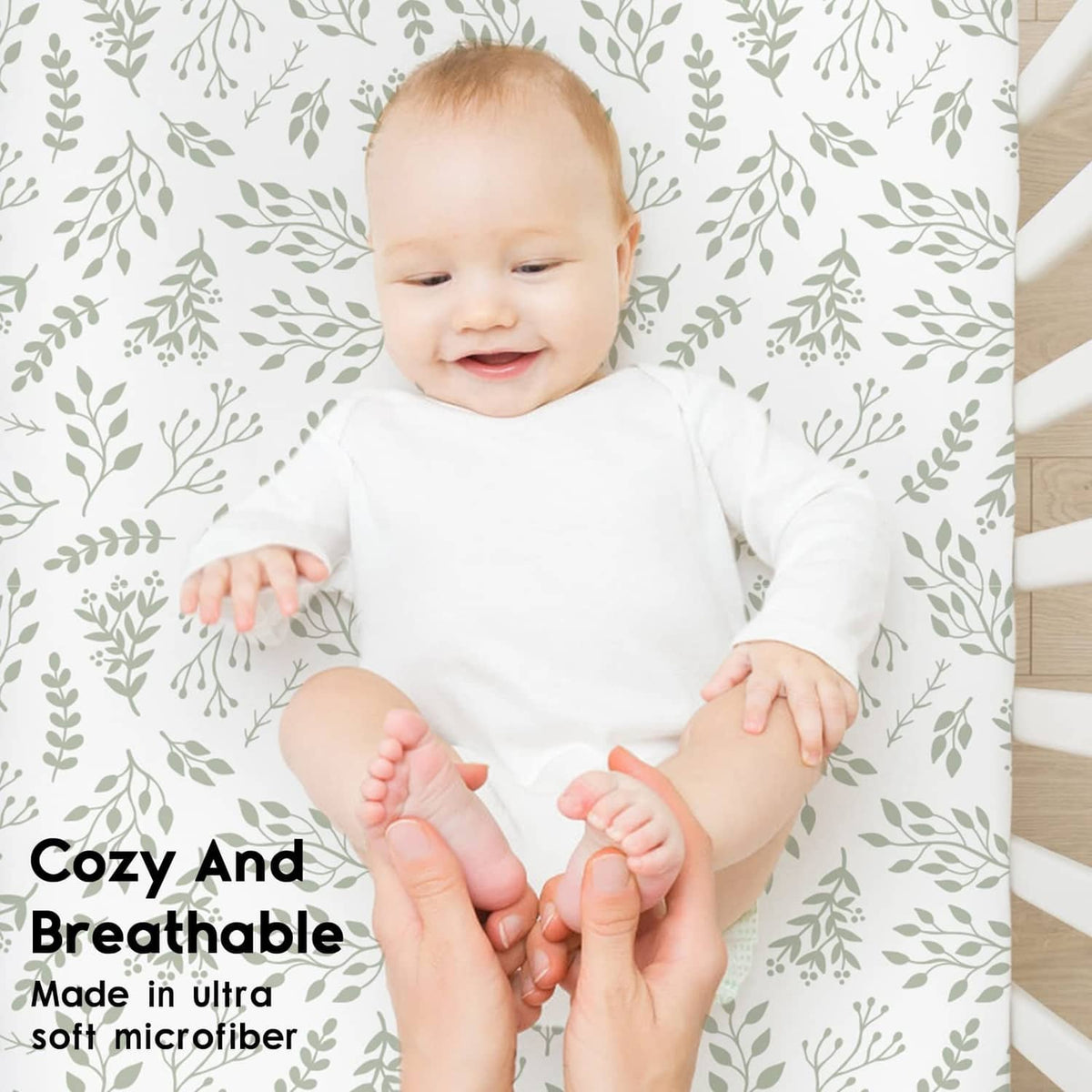 Fitted crib sheet with white background and green leaf pattern for crib mattress