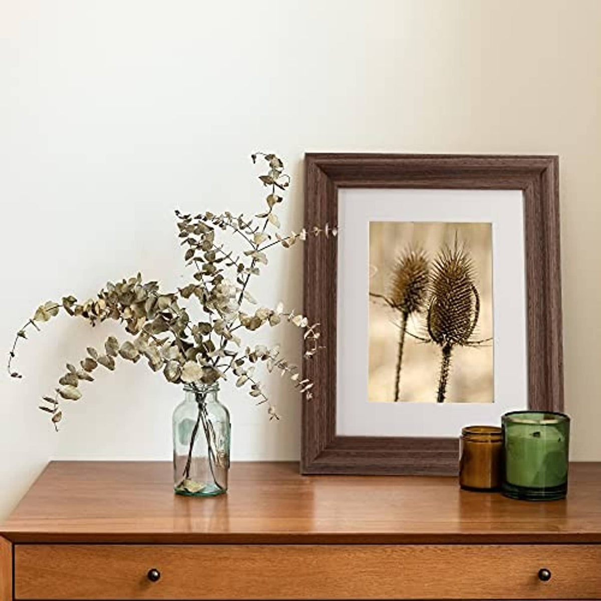 Brown wood photo frame with white mat, standing on a surface.