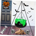 Black witch cauldron hanging on tripod stand with green glow spider web lights
