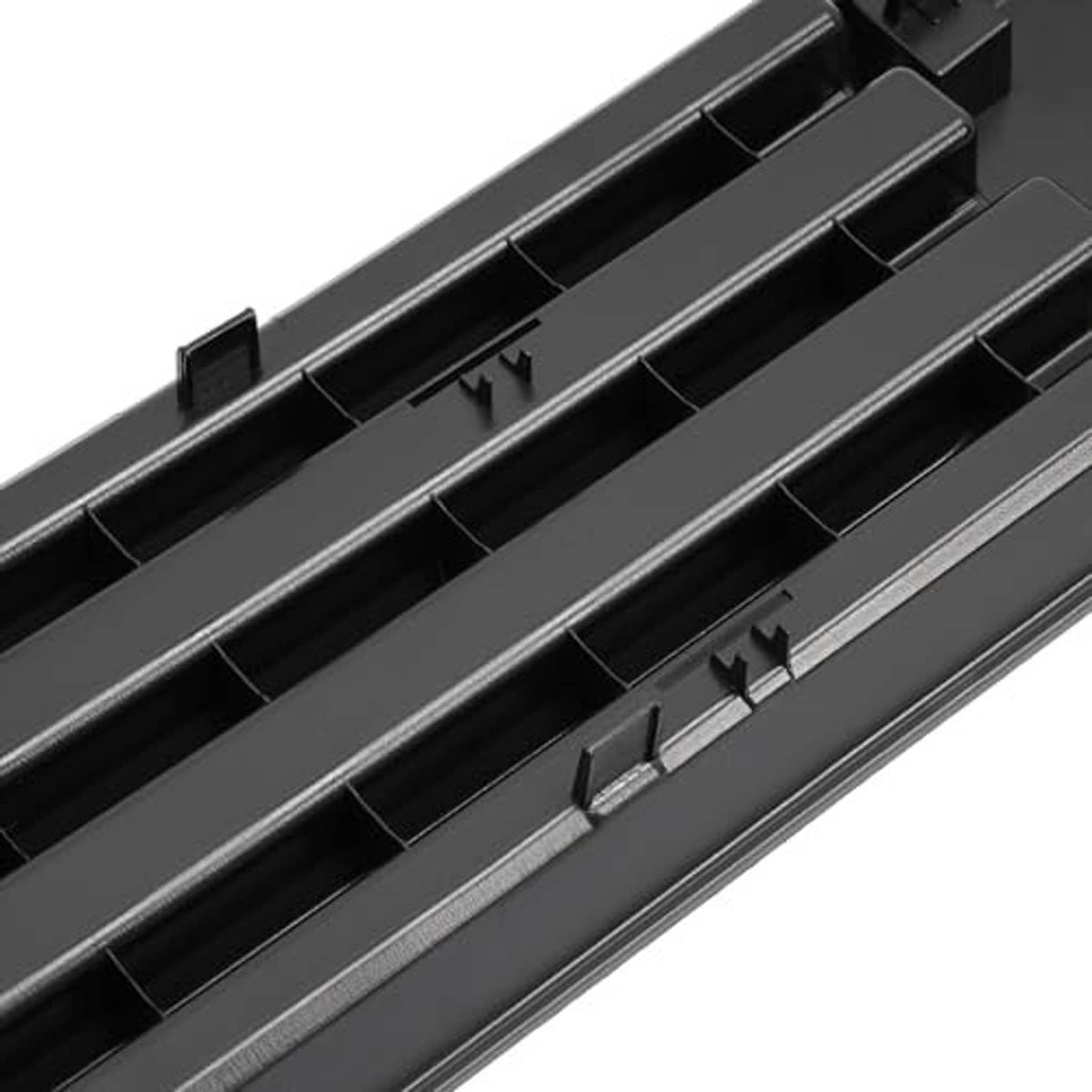 Close-up of black grille insert with horizontal slats and raised mounting points