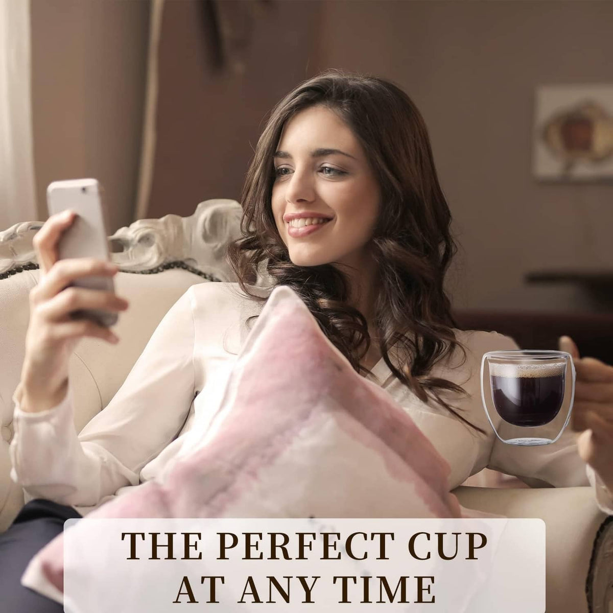Clear double-wall glass espresso cup with side handle, filled with dark coffee