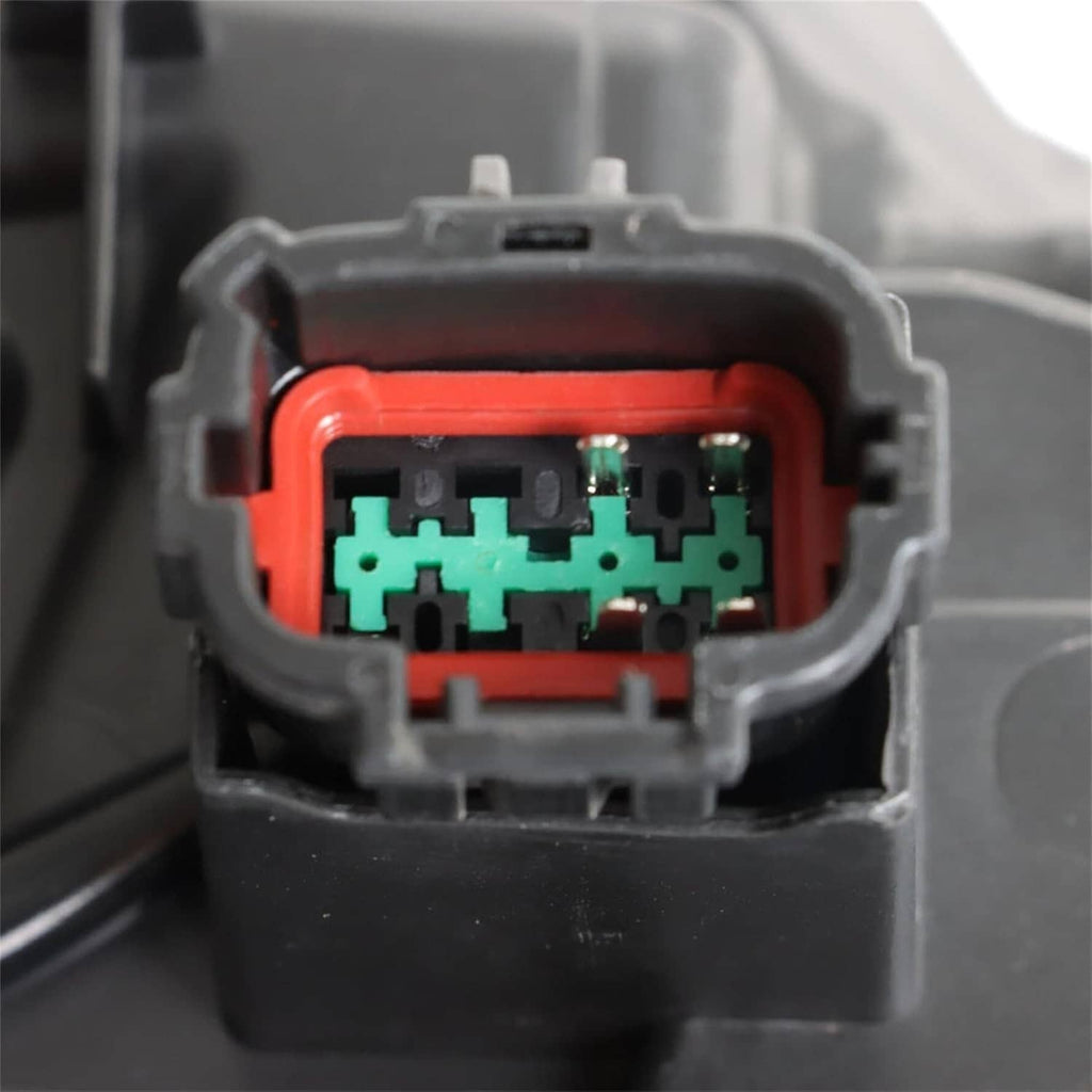 Close-up of headlight connector with green circuit board and orange housing section.