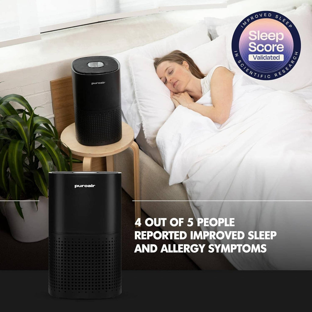 Black air purifier on bedside area, top vent and front grille clearly shown