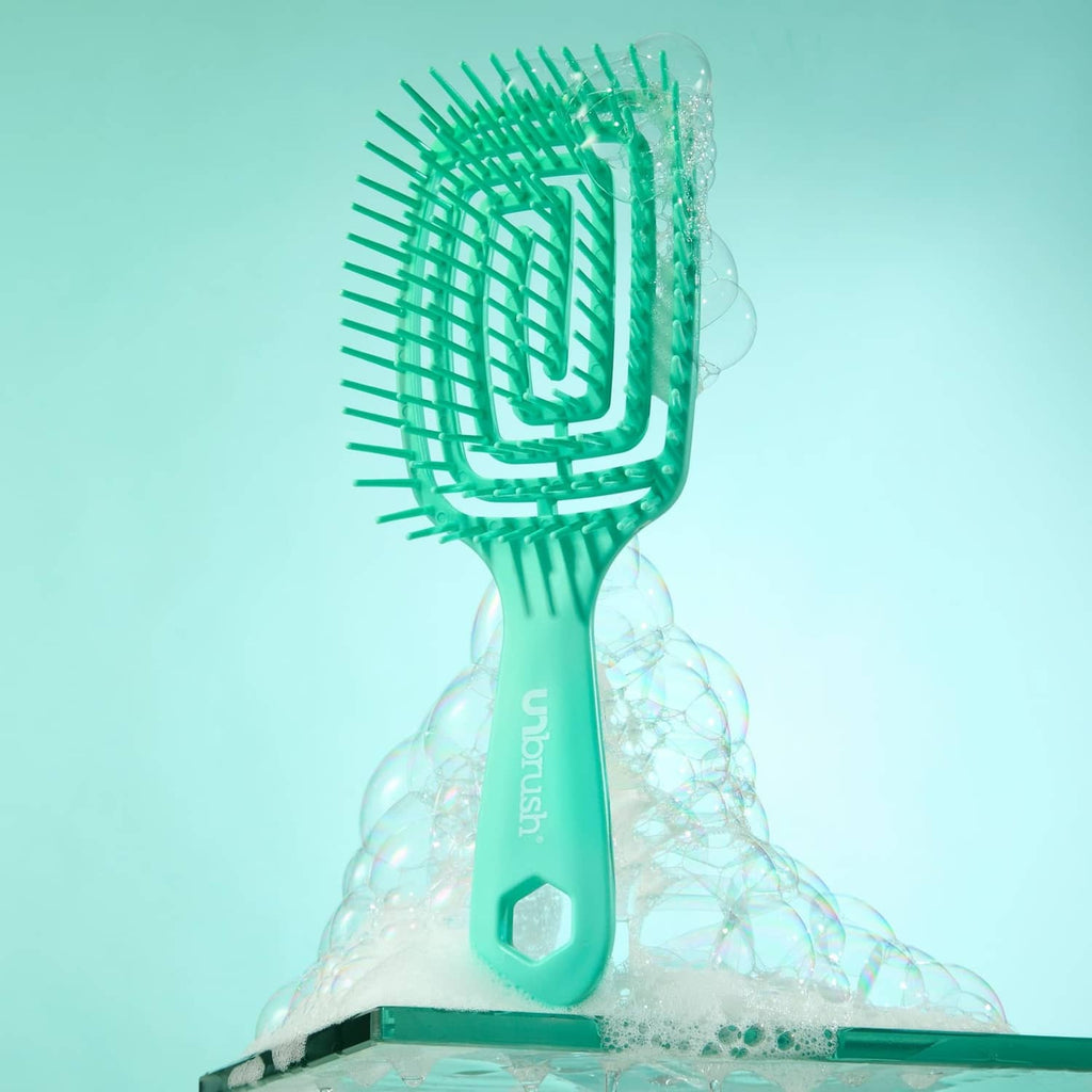 Teal detangling hairbrush with cushioned bristle head, water droplets around