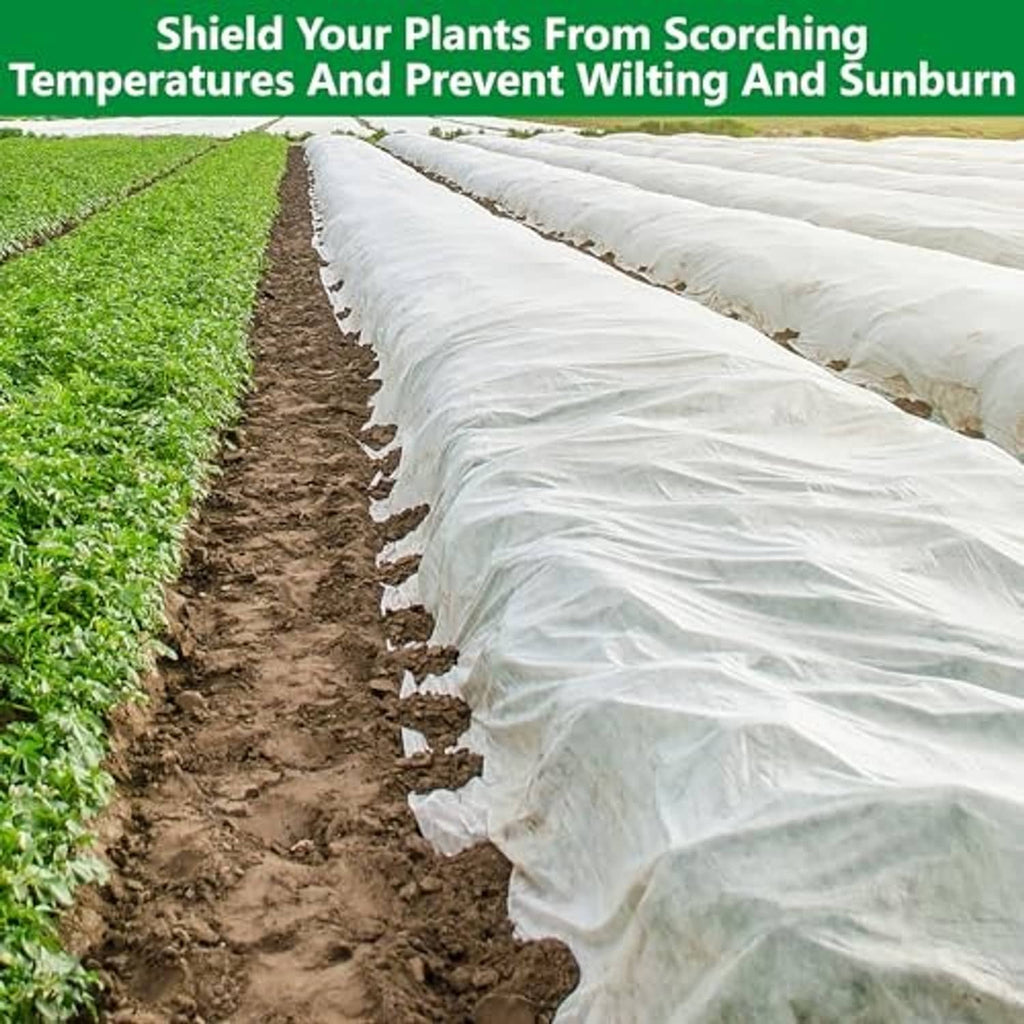 White garden row cover cloth spanning plants to help prevent wilting and sunburn