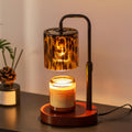 Candle warmer lamp with amber tortoise-shell glass shade and lit candle on round base