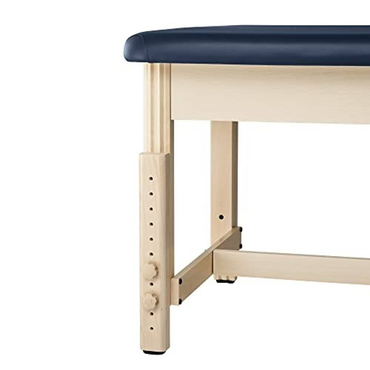 Stationary treatment table corner detail showing dark blue pad on light wood base