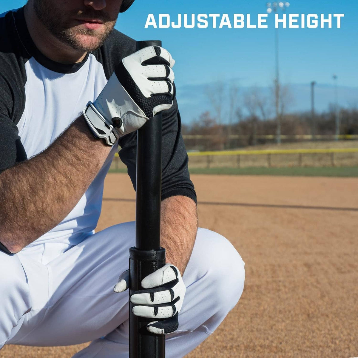 Adjustable height batting tee with gloved player holding the post