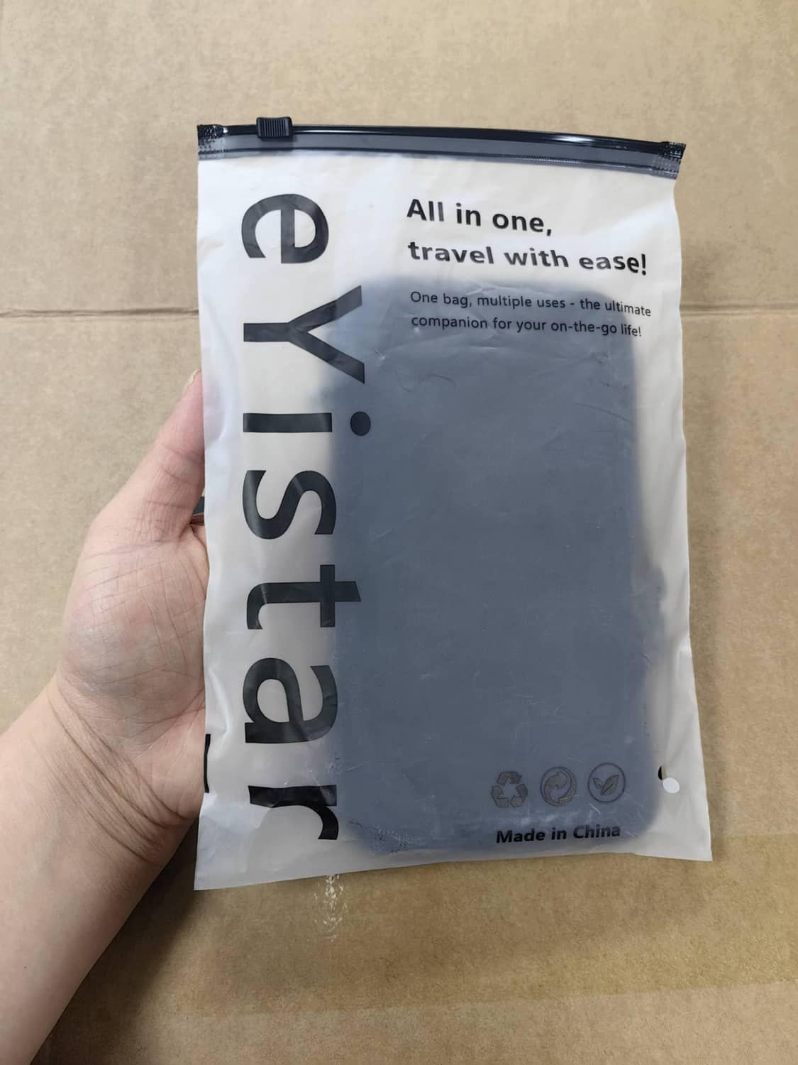 White retail package bag for travel case held in hand, with clear window