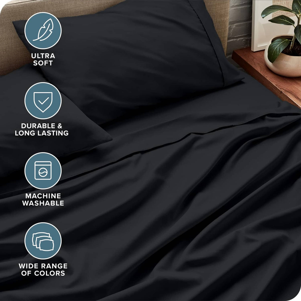 Black bed sheet fabric close-up with smooth surface and layered folds