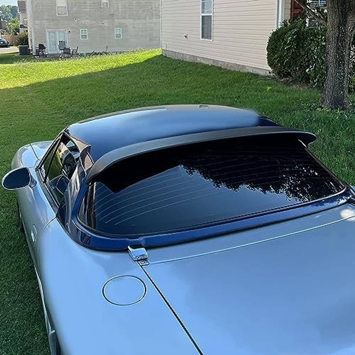 Matte black rear window roof spoiler installed on a blue hardtop car