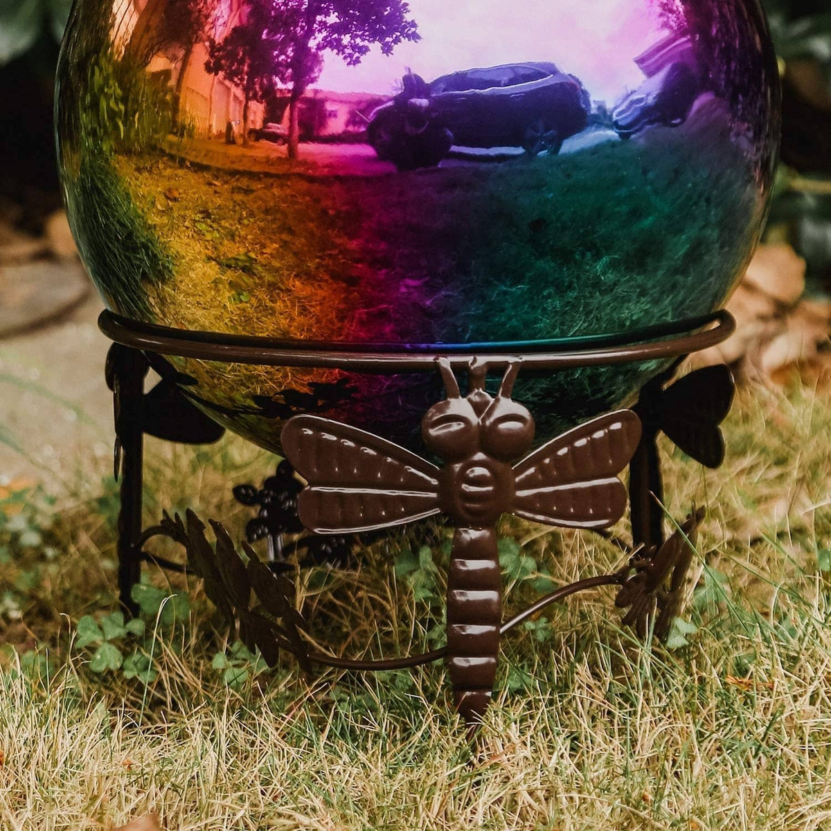 Metal gazing ball stand with reflective rainbow gazing ball, close-up view.