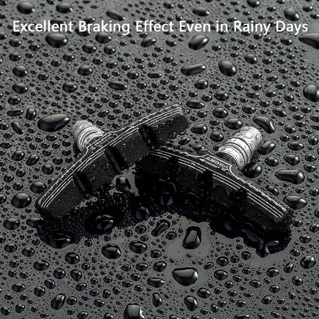 Black textured rubber V-brake brake pads shown on a wet surface