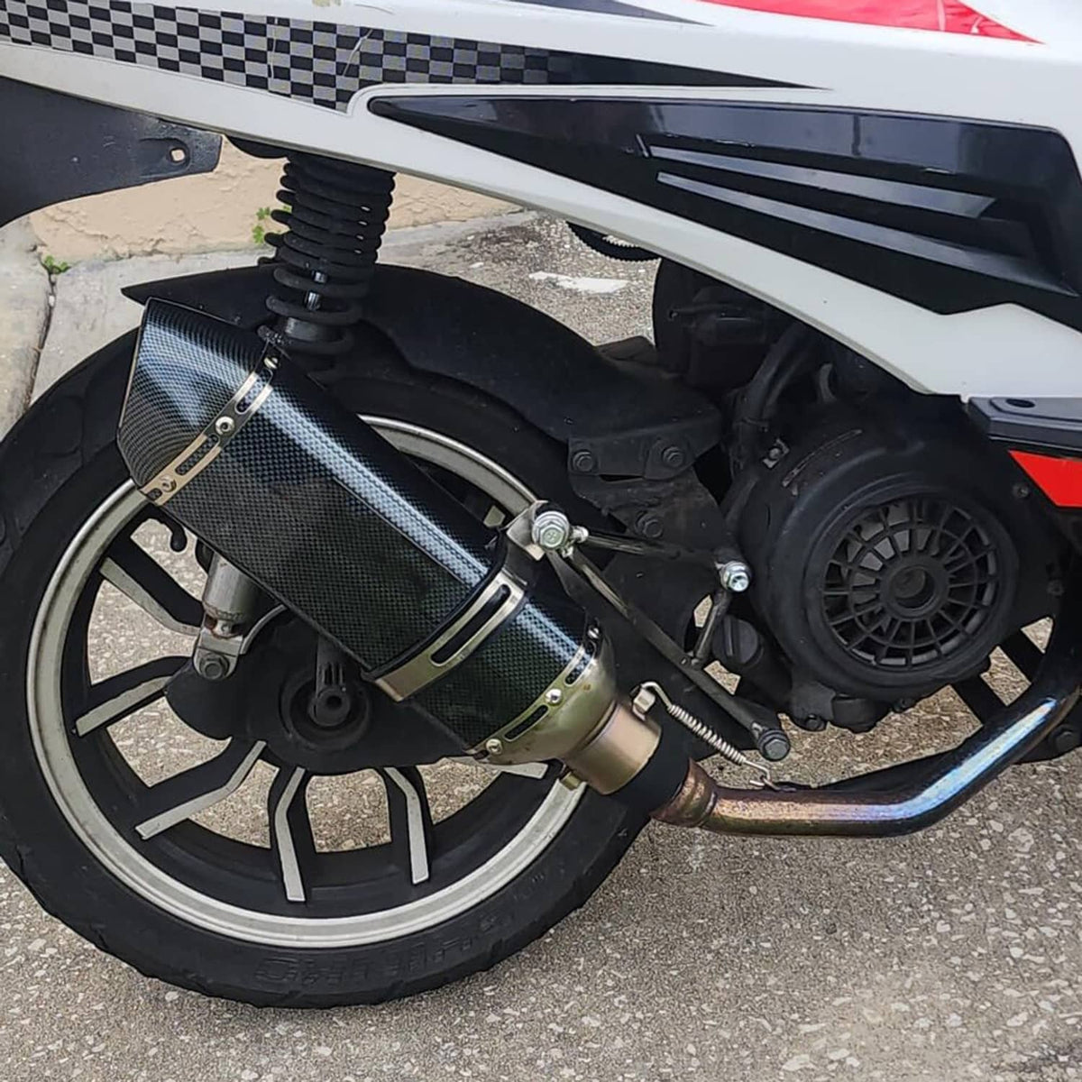 Installed motorcycle exhaust muffler with carbon fiber canister and chrome header pipe