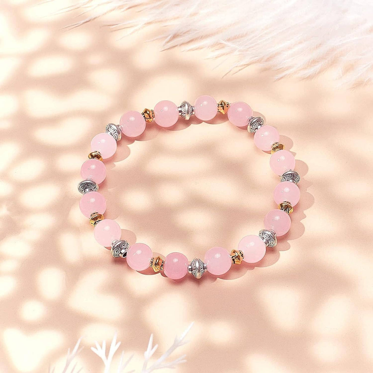 Antique silver spacer beads on a pink bead bracelet with round silver charm spacers
