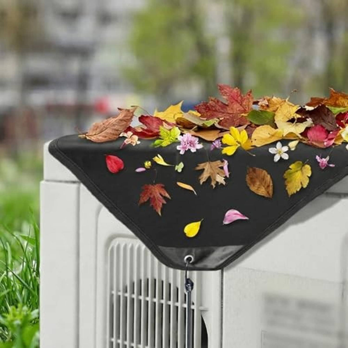 Black AC cover with front drawstring and small grommet, outdoors over condenser.