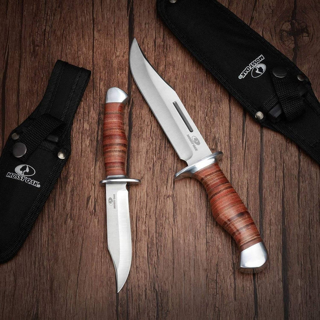 Fixed-blade Bowie knives with wood handles and black sheaths laid on a wooden surface
