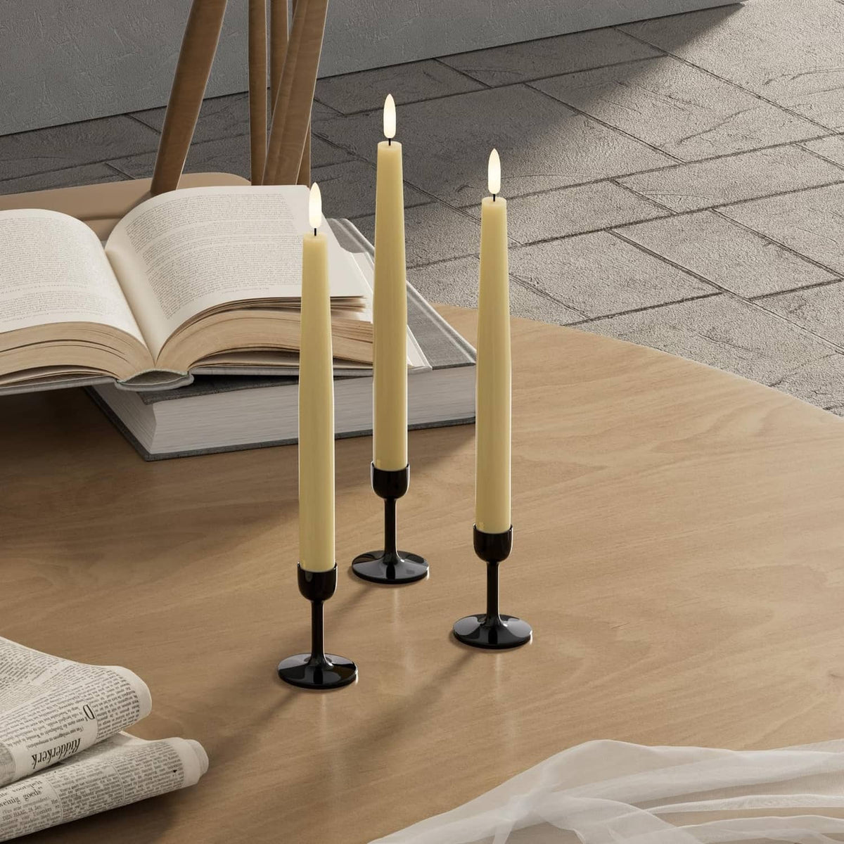 Three ivory flameless taper candles with black bases