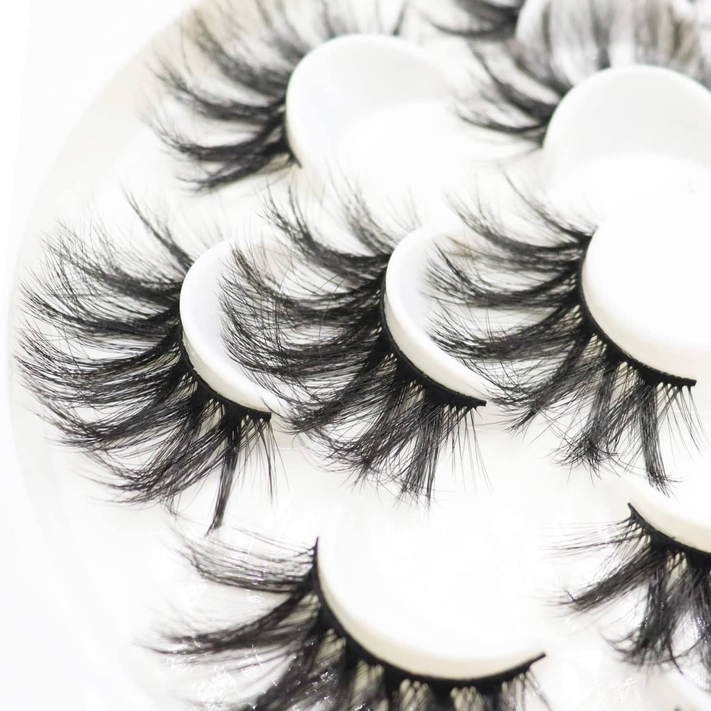 Layered black false eyelashes with curved bands stacked in a clean circular display.