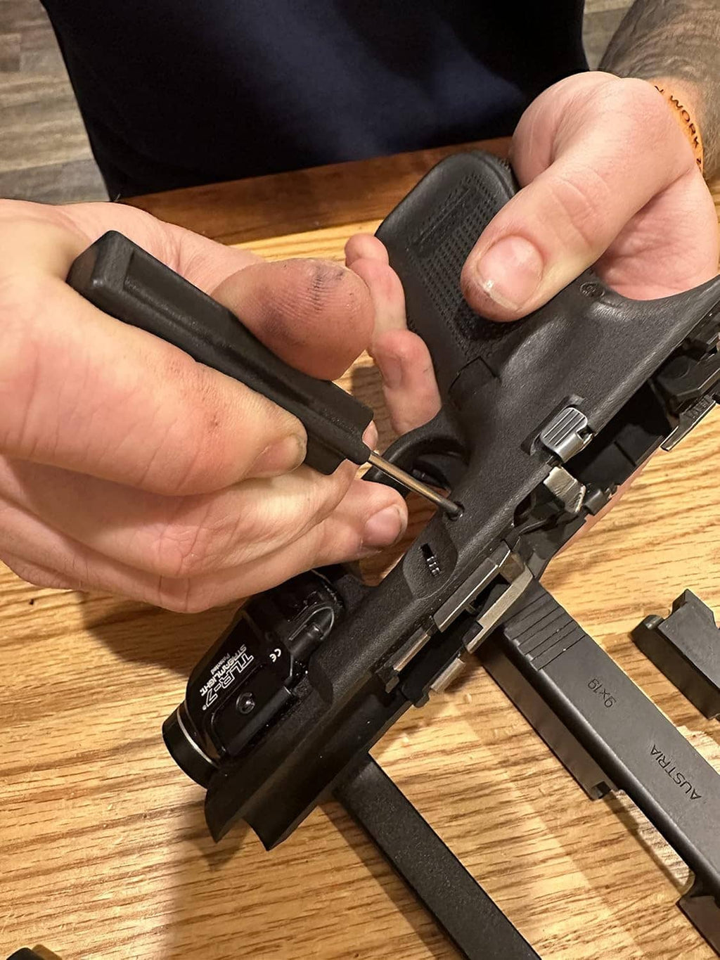 Handheld pistol disassembly tools with black handles and metal rods