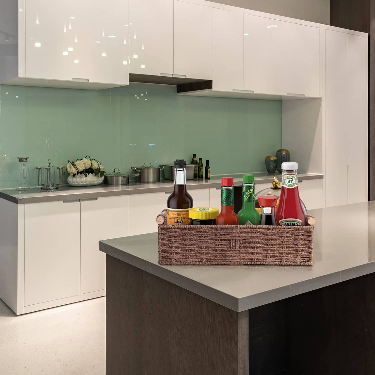 Rectangular brown woven basket with side handles on a kitchen counter