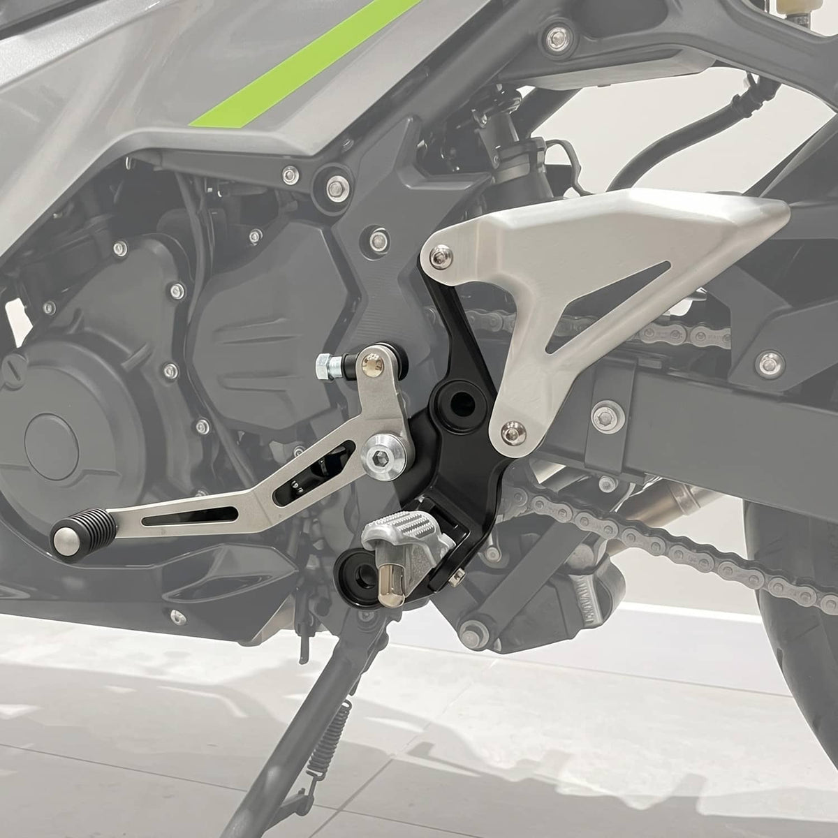 Installed motorcycle foot peg bracket on engine side with silver plate and black mounting